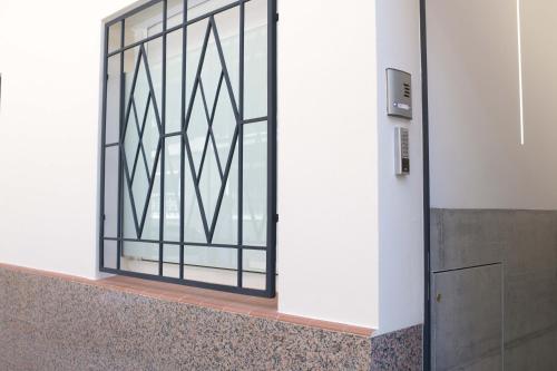 une porte avec fenêtre dans un bâtiment dans l'établissement Boutique Plaza Catalonia Suites Cornellá, à Cornellà de Llobregat