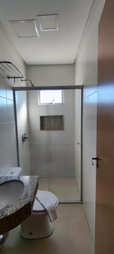 a bathroom with a shower and a toilet and a sink at Sudoeste Hotel in Goiânia