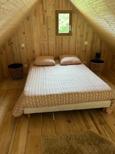 Ce lit se trouve dans un chalet en bois. dans l'établissement Chalet à la campagne, à Colonard-Corubert