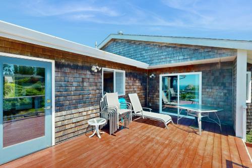 a house with a deck with a table and chairs at Firepit Lagoon in Oceanside