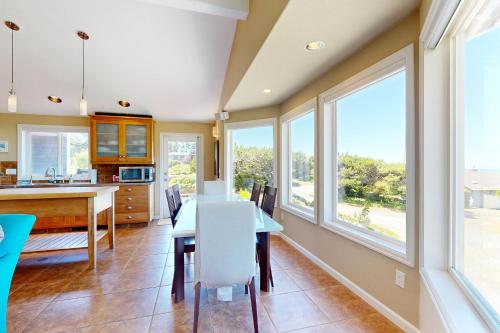 a kitchen with a table and chairs and windows at Firepit Lagoon in Oceanside