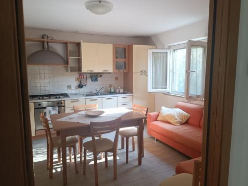 a kitchen and dining room with a table and a couch at La Sirenetta in Tortoreto Lido