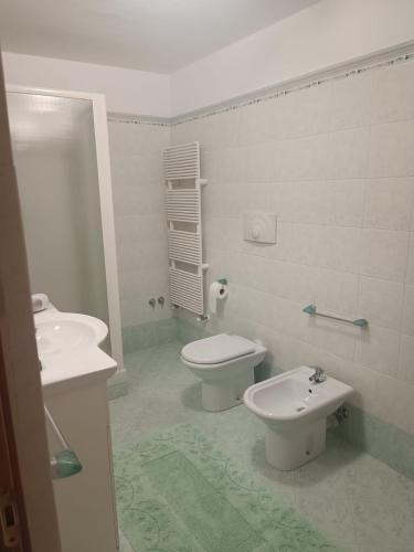 a white bathroom with a toilet and a bidet at La Sirenetta in Tortoreto Lido