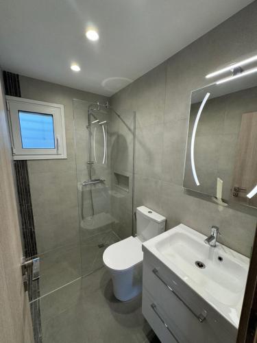 a bathroom with a toilet and a sink and a shower at PUERTO VILLA, Best Location in Porto Rafti in Porto Rafti
