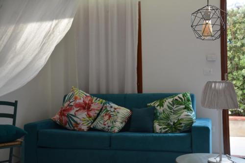a blue couch with pillows in a living room at La Cicala in Brolo