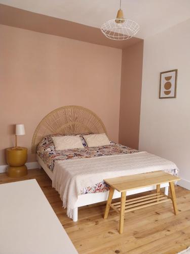 une chambre avec un lit et une table en bois dans l'établissement Au 26 Calais T3, à Calais