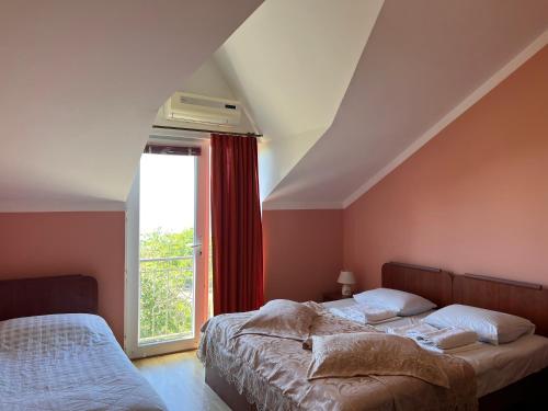 a bedroom with two beds and a window at Green Garden Hotel in Makhinjauri