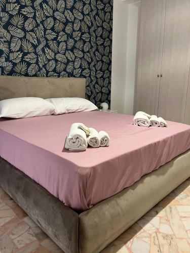 a pink bed with towels on top of it at Labanca's Comfort in Matera