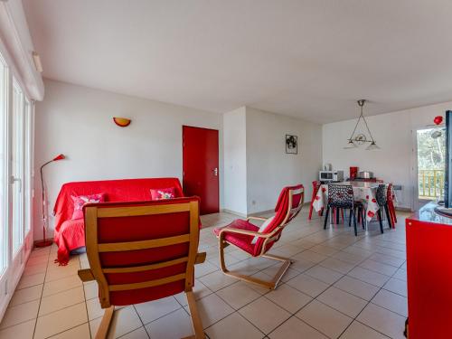 - un salon avec un lit rouge et une salle à manger dans l'établissement Appartement Confortable Proche Océan avec Parking et Terrasse - 7 Pers - FR-1-521-244, à Biscarrosse
