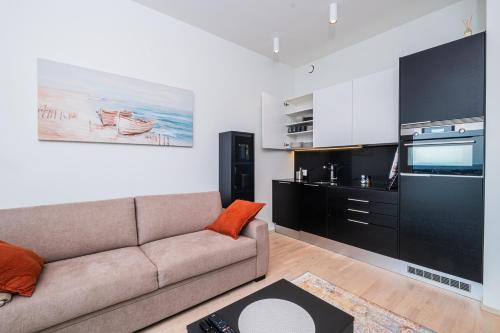 a living room with a couch and a large tv at 26th Floor Helsinki High Point 1 BDR Apartment with City View in Helsinki