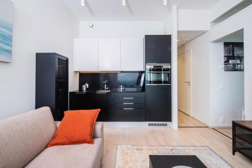 a living room with a couch and a kitchen at 26th Floor Helsinki High Point 1 BDR Apartment with City View in Helsinki