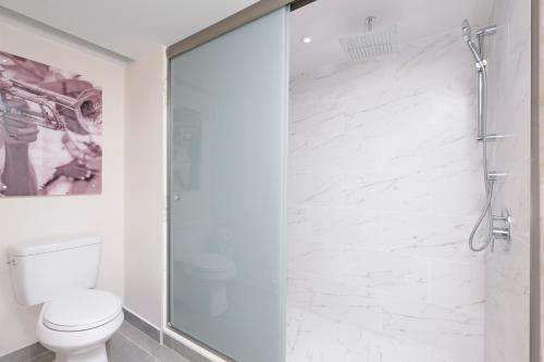 a bathroom with a toilet and a glass shower at Royalton CHIC Antigua, An Autograph Collection All-Inclusive Resort - Adults Only in Saint Johnʼs