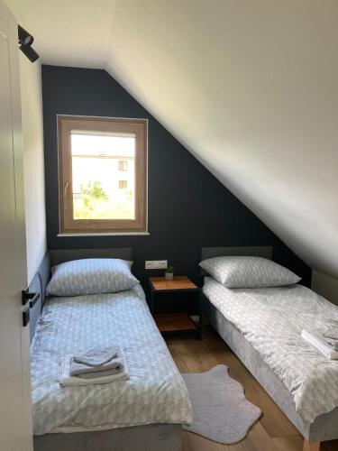 two beds in a room with a window at Pogodny Zakątek in Mosty