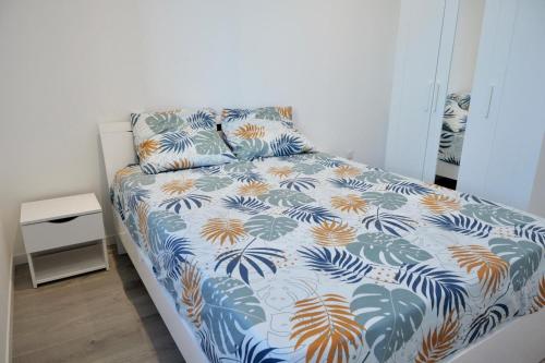 une chambre avec un lit à motifs bleu et orange dans l'établissement T3 climatisé vue rade et Mont Faron, calme à la Corniche, à Toulon