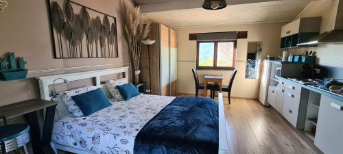 une chambre avec un grand lit et une cuisine dans l'établissement Studio de charme + terrasse : Verdon, lac, plages, à Claviers