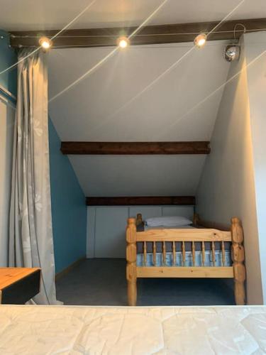 une chambre avec un lit en bois dans une pièce dans l'établissement Maison de la cigale enchantée, à La GrandʼCombe