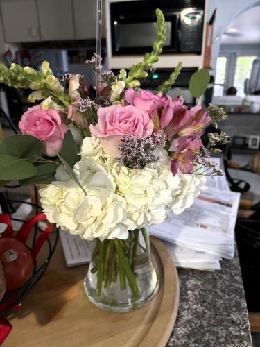 a vase filled with pink and white flowers on a table at Patuca Home in Tamiami