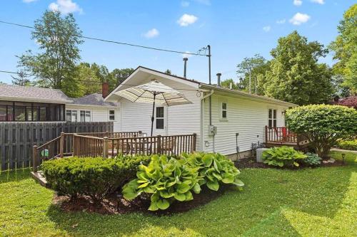 a white house with an umbrella and some bushes at 2min walk downtown-Pet Friendly-Offstreet Parking in Saugatuck