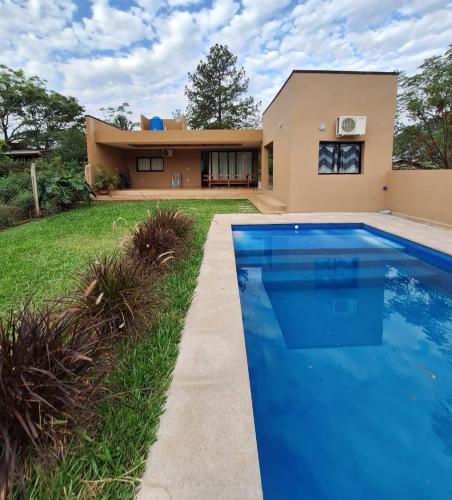 a house with a swimming pool in front of a house at Casa El Bosque in Candelaria