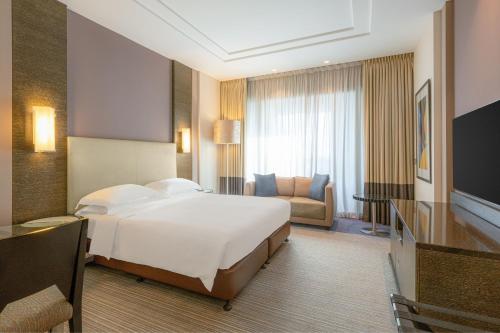 a hotel room with a bed and a couch at Four Points by Sheraton Al Ain in Al Ain