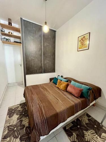 une chambre avec un grand lit avec des oreillers colorés dans l'établissement Magnifique T3 au Centre Ville - Immeuble particulier, à Montpellier