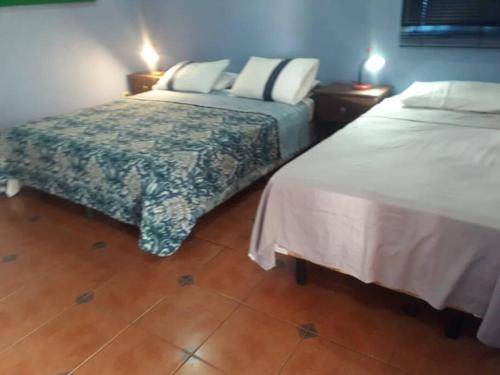 a hotel room with two beds and two lamps at Villa La Giralda - Lakefront - Pool - View - Relaxation Haven in Masaya