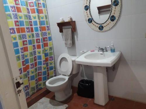 a bathroom with a toilet and a sink and a mirror at Villa La Giralda - Lakefront - Pool - View - Relaxation Haven in Masaya