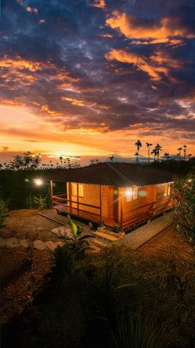 a house on the beach with a sunset in the background at Luz de Luna Glamping in Veracruz