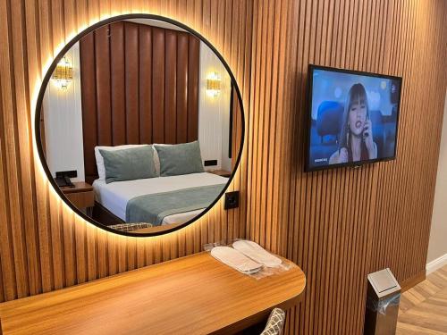 a bedroom with a bed and a mirror on a wall at Gumus Palace Hotel in Istanbul