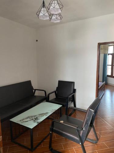 a living room with a couch and a table and chairs at Hotel new plazza in Kisangani