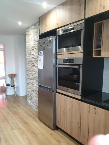 La cuisine est équipée d'un four et d'un réfrigérateur en acier inoxydable. dans l'établissement Cosy T3, proche centre ville, à Aix-en-Provence