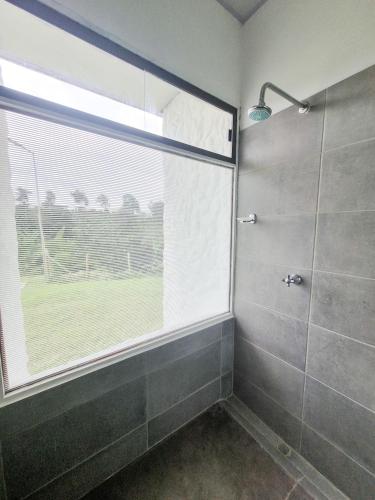 a bathroom with a shower with a large window at Tumbaga Hostal in Quimbaya