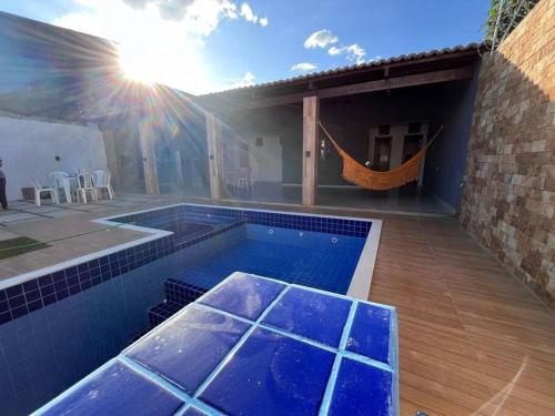 a swimming pool with a hammock next to a house at Casa para aluguel de temporada in Crato