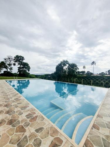 a large swimming pool with blue water at Tumbaga Hostal in Quimbaya