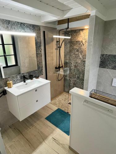a bathroom with a white sink and a shower at Côté Rivière in Ézy-sur-Eure