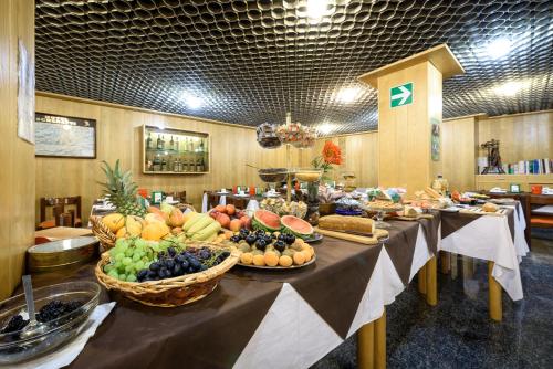 einen Tisch mit viel Obst und Gemüse in der Unterkunft Hotel Schenatti in Sondrio