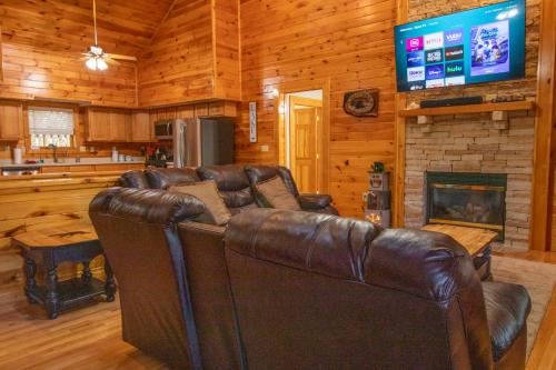 a leather couch in a living room with a fireplace at Hibernation Haven in McHenry