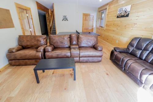 a living room with two leather couches and a table at Hibernation Haven in McHenry