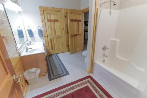 a bathroom with a tub and a sink and a toilet at Hibernation Haven in McHenry