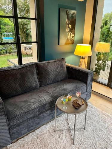 a living room with a leather couch and a table at Côté Rivière in Ézy-sur-Eure