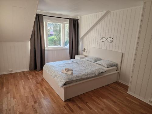 una camera da letto bianca con un letto e una finestra di Aadarsh Villa rom3, 10 min fra Oslo airport a Gjerdrum
