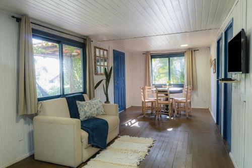a living room with a couch and a table at Pousada Villa Agrifoglio in Praia do Rosa