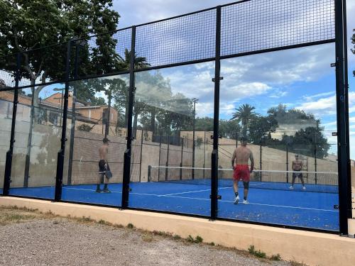 a group of men playing tennis on a tennis court at Mobil home vue exceptionnelle et spa - Domaine de l'Ile d'Or in Saint-Raphaël