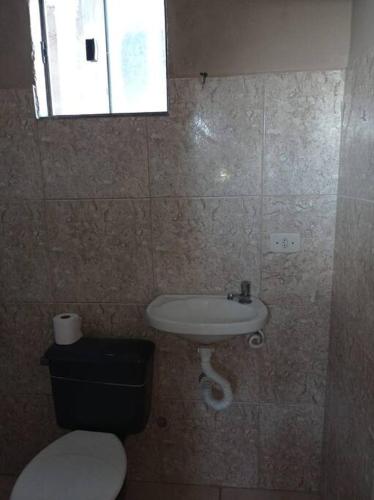 a bathroom with a toilet and a sink at Residencial Barbosa - Apto 301 in Macaé