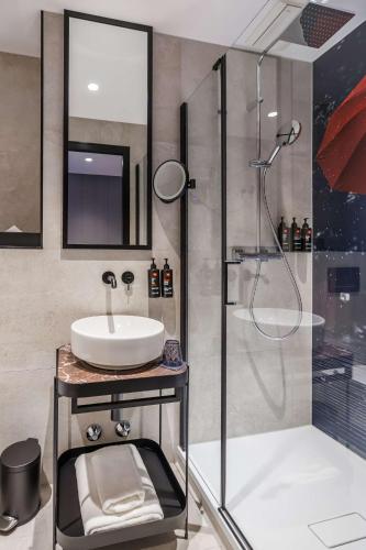 ベルリンにあるRadisson RED Berlin Kudammの洗面台とシャワー付きのバスルーム