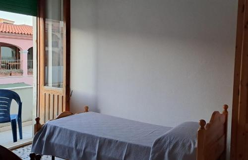 a bedroom with a bed and a large window at La rosa del mare in Isola Rossa