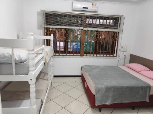 a bedroom with a bunk bed and a window at Linda Casa na Praia de Bombas in Bombinhas