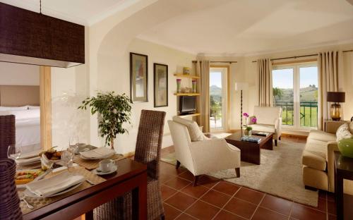 a living room with a couch and a table and chairs at Dolce CampoReal Lisboa in Turcifal