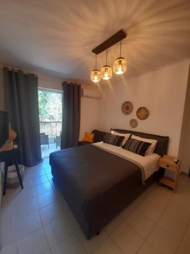 a bedroom with a large bed and two lights at Chic & Calm apartment 3 minutes walk to Rafina Beach in Rafina