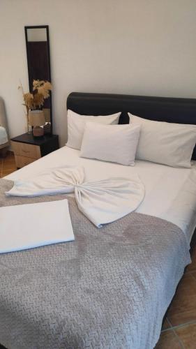 a large bed with white sheets and pillows on it at Lula Apartments in Ulcinj